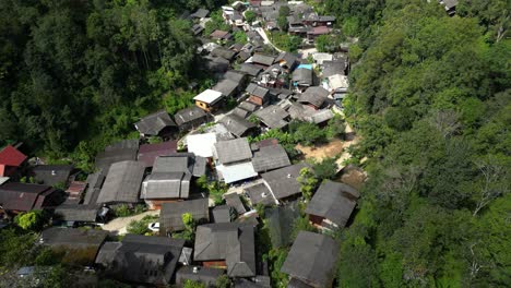 Neigen-Sie-Die-Drohne-Nach-Oben,-Um-Den-üppigen-Dschungel-Mit-Einem-Versteckten-Dorf-In-Thailand-Zu-Enthüllen