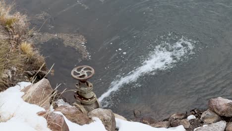 Open-Gate-Valve-filling-a-pond-with-snow-melting-nearby