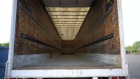 Looking-into-an-empty-white-semi-truck-cargo-trailer-before-receiving-packages,-static