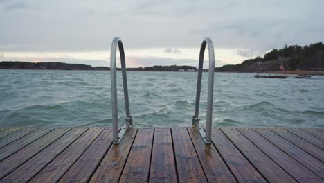 Waves-rocking-a-small-wooden-pier-on-a-cloudy-day