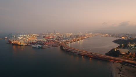 Aerial-Shot-Of-Algeciras-Shipping-Port-Near-Suspended-Long-Bridge-At-evening-Time,-Spain