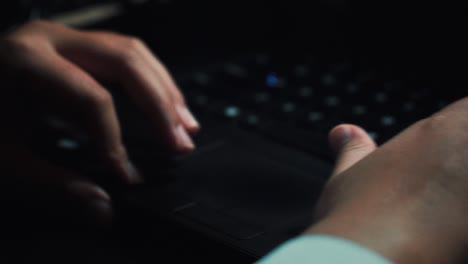 Slow-motion---Close-up-finger-of-person-wear-ring-is-touching-touchpad-of-laptop-at-night-under-the-light