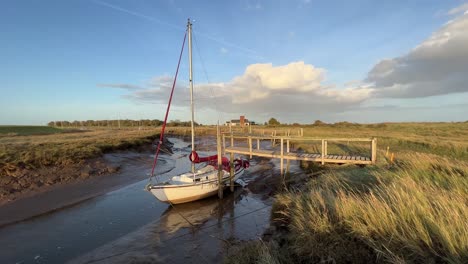 Sail-boat-docked-in-the-estuary-with-evening-golden-sunlight