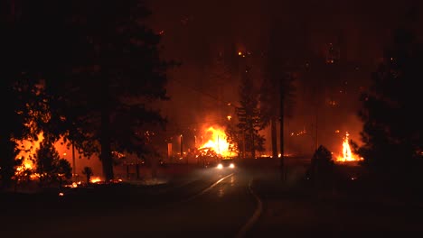 Firefighters-driving-on-a-road-in-middle-of-raging-forest-fires,-during-nighttime