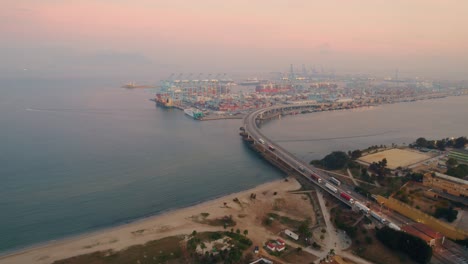 Aerial-view-heading-towards-Port-of-Algeciras-commercial-freight-shipping-container-port,-coastal-Cadiz-at-sunset