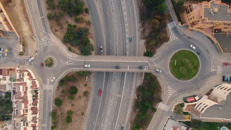 Aerial-view-directly-above-Spanish-roundabout-intersection-over-busy-motorway-route-traffic