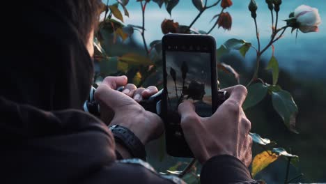 Slow-motion-video---Close-up-shot-of-a-man-with-a-black-mask-and-jacket-taking-landscape-photos-using-a-smartphone