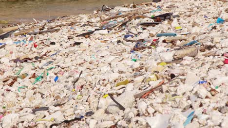 Statisches-Stativ-Aus-Künstlichem-Plastikmüll-Und-Müll,-Der-Langsam-An-Der-Felsigen-Küste-In-Der-Karibik-Angespült-Wird