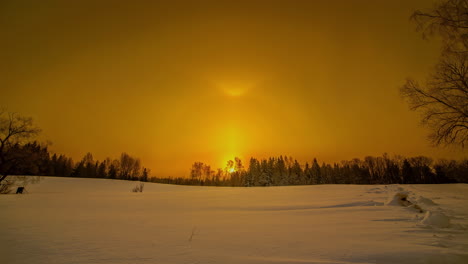 Golden-yellow-sun-halo-sunrise-over-a-magical-winter-field---time-lapse