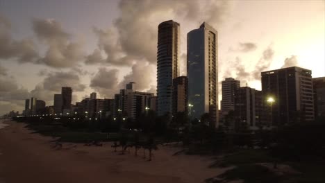 Tiro-De-Playa-Panorámico-Hasta-Rascacielos-Y-Nubes-Esponjosas-En-Brasil