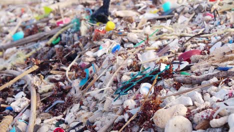 Nahaufnahme-Rack-Fokus-Auf-Müll,-Der-Am-Sommertag-Am-Tropischen-Strand-Verstreut-Ist