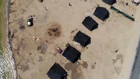 Aerial-Top-Down-View-Of-Row-Of-Black-Tents-Surrounded-By-Floodwater-In-Jacobabad