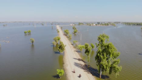 Aerial-Along-Lone-Road-Surrounded-By-Flood-Waters-Into-The-Horizon-In-Jacobabad,-Sindh