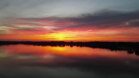 Luftaufnahme-Eines-Lebendigen-Sonnenuntergangs-über-Einem-See