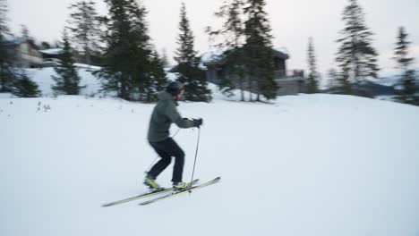 4K-tracking-of-skier-going-downhill-fast-on-the-ski-slope-on-telemark-skis-on-a-cold-cloudy-day-in-ski-resort-in-Norway