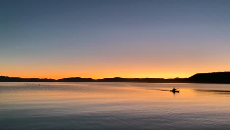 A-single-person-kayak-on-a-dreamy-twilight-lake-landscape