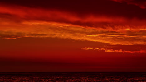 Amanecer-Rojo-Con-Nubes-Flotando-Lentamente-Sobre-El-Mar