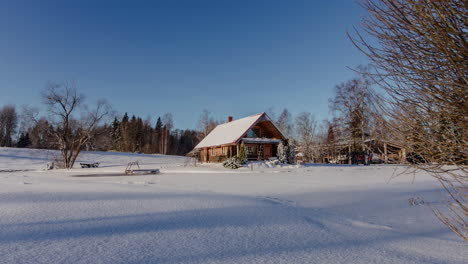 Zeitraffer-Einer-Malerischen-Winterblockhütte,-Umgeben-Von-Schnee-Mit-Schatten-Von-Bäumen,-Die-Auf-Dem-Boden-Vorbeiziehen