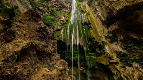Time-lapse-of-water-falling-through-a-cave-with-mossy-walls