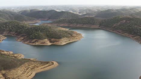 Vuelo-De-Drones-Sobre-La-Cuenca-De-Drenaje-Con-Vistas-Al-Agua-Azul-Y-Las-Montañas-Circundantes