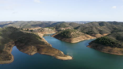 Vuelo-De-Drones-Sobre-El-Agua-Azul-Del-Lago-Santa-Clara-Y-Las-Montañas-En-La-Región-Del-Algarve-En-Portugal