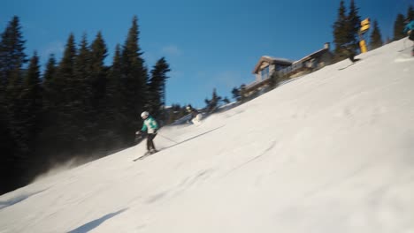 4K-tracking-of-group-of-skiers-going-downhill-at-fast-pace-on-a-sunny-winter-day-in-a-Norwegian-mountain-ski-resort