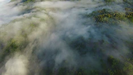 Upslope-fog-forming-in-the-lush-rainforest-of-tropical-Guanacaste-Province,-Costa-Rica,-aerial