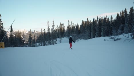 4K-Tracking-Von-Mädchen,-Die-An-Einem-Sonnigen-Wintertag-Mit-Blauem-Himmel-In-Norwegen-Bergab-Auf-Der-Piste-Snowboarden