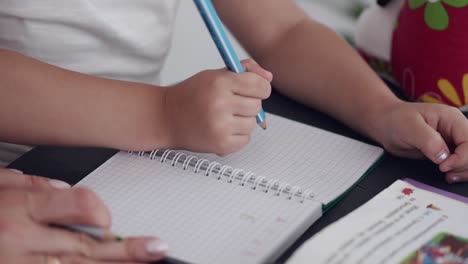 Primer-Plano-De-Las-Manos-De-Una-Joven-Estudiante-Escribiendo-En-Un-Cuaderno-Estudiando-En-Casa
