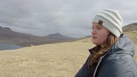 Medium-Close-Up-of-a-Young-Woman-in-the-Faroe-Islands-Looking-Out-on-a-Hill