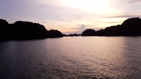 Sonnenuntergang-Mit-Einem-Fahrenden-Boot-Gegen-Hügel-In-Misool,-Raja-Ampat,-Indonesien,-Asien