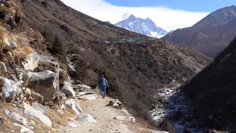 A-person-walking-on-a-mountain-trail-in-the-Himalaya-Mountains-in-Nepal