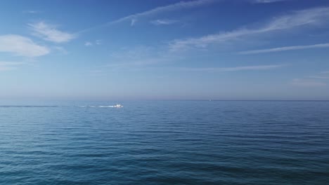 Ruhiger-Blauer-Ozean-Mit-Vorbeifahrendem-Boot