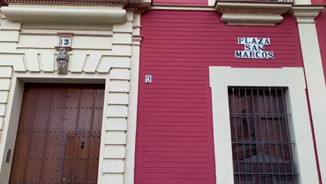 Close-Up-Red-Facade-with-Plaque-in-San-Marcos-Square-Seville