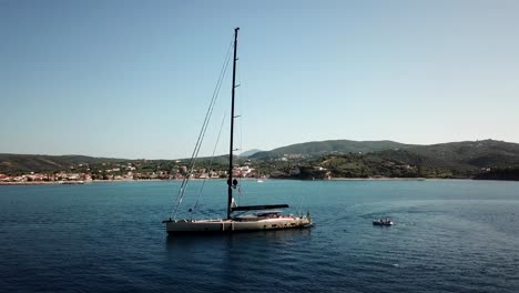 Drone-view-of-a-sailing-ship-in-Greece,-with-the-shore-behind