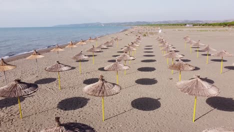 Sombrillas-En-La-Playa-De-Arena-Abandonada-En-Albania-Durante-La-Temporada-De-Verano-Tardío---Vista-Aérea