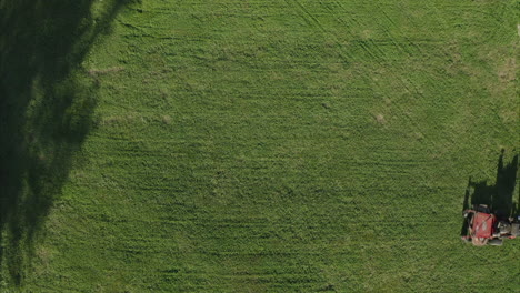 Man-mowing-the-lawn-with-stand-up-riding-lawn-mower,-cinematic-aerial-drone-shot-high-angle