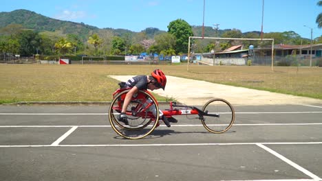 A-kid-with-disability-driving-a-handbike-at-a-paracycling-race,-striving-to-win