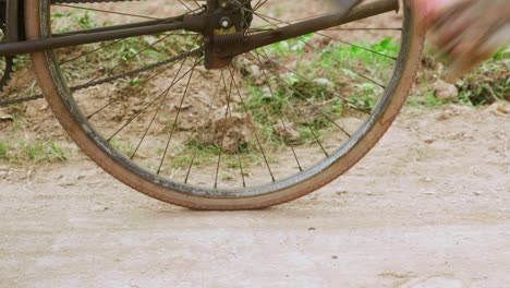 Close-up-view-of-the-legs-of-a-man-wearing-old-brown-shoes-while-getting-up-on-a-bicycle-before-leaving-in-Lang-Son-city,-Vietnam-with-the-view-of-agricultural-field-at-daytime