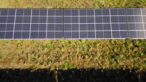 Solar-Panels-On-An-Energy-Farm---aerial-drone-shot