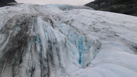 Aerial-view-of-details-on-a-thawing-Glacier-with-sooty-ice-and-glacial-water---climate-change-concept