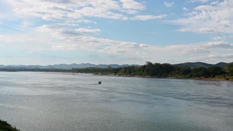 A-touring-bout-turning-around-navigating-the-moving-water-of-the-Mekong-River,-Thailand-and-Laos