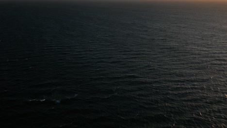 Drohne-über-Dem-Ozean,-Die-Eine-Epische,-Wolkenbedeckte-Sonnenuntergangssilhouette-Des-Tafelbergs-Enthüllt