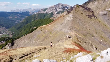 Woman-Hikes-Downhill-a-Mountain-Trail-in-Prokletije-National-Park,-Montenegro---Dolly-Follow