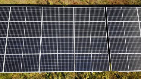 Flying-Over-Solar-Panels-Field-At-Daytime---aerial-sideways