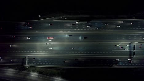 Cars-rushing-through-highway-traffic-at-night,-flying-view-from-above,-Highway-401-Canada