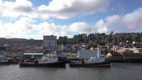 Commercial-fishing-boats-docked-at-harbor-in-Coos-Bay-at-the-Oregon-Coast,-drone-fly-by