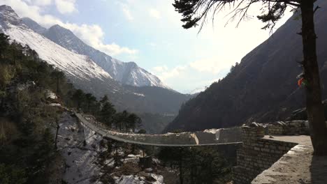 A-swinging-bridge-spanning-a-valley-in-the-bright-afternoon-sunshine-in-the-Himalaya-Mountains-of-Nepal