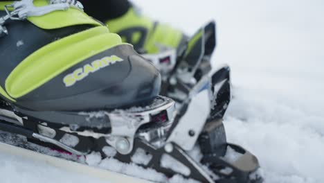 Close-up-of-telemark-ski-boot-attaching-and-connecting-to-the-ski-securely-in-the-snow