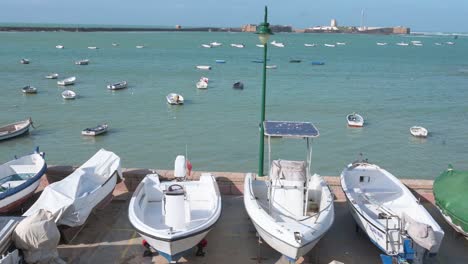 Boats-are-seen-put-aside-on-the-dock-at-the-seafront-promenade-in-Cadiz,-Spain